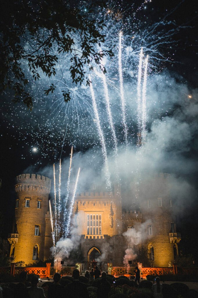 Feuriges Hochzeitsfeuerwerk vor dem beleuchteten Schloss Moyland mit Gästen im Vordergrund
